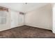 Neutral bedroom featuring a white door, dual windows, and neutral carpeting at 5901 E Leonora St, Mesa, AZ 85215