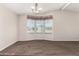 Dining area with neutral walls, carpet flooring, a chandelier, and a large window with blinds at 5901 E Leonora St, Mesa, AZ 85215
