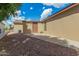 Exterior shot of tan house and yard with rock landscaping and detached shed at 5901 E Leonora St, Mesa, AZ 85215