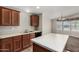 Kitchen featuring wood cabinetry, stainless steel sink, and tile flooring at 5901 E Leonora St, Mesa, AZ 85215