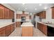 Eat-in kitchen with center island, stainless steel appliances, and wood cabinetry at 5901 E Leonora St, Mesa, AZ 85215