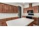 Kitchen featuring wood cabinetry, a center island, and a black microwave and stove at 5901 E Leonora St, Mesa, AZ 85215