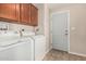 Laundry room featuring tile floors, cabinets, washer, dryer and exit door at 5901 E Leonora St, Mesa, AZ 85215