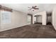 Open living room features plush carpeting, natural light, and archways to other rooms at 5901 E Leonora St, Mesa, AZ 85215