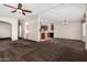 Bright, open-concept living area with plush carpeting leading to the kitchen and dining space at 5901 E Leonora St, Mesa, AZ 85215