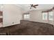 Spacious living room with plush carpeting, ceiling fan, and natural light from large windows at 5901 E Leonora St, Mesa, AZ 85215