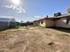 Spacious dirt backyard, partially fenced, featuring external building features at 7961 W Campbell Ave, Phoenix, AZ 85033