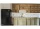 Close-up of a kitchen featuring tile countertops, vintage wood cabinets, and black appliances at 7961 W Campbell Ave, Phoenix, AZ 85033