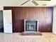 Living room with brick fireplace, wood paneling, and tile flooring at 7961 W Campbell Ave, Phoenix, AZ 85033