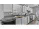 Galley kitchen featuring white cabinets and black appliances at 8103 E Southern Ave # 205, Mesa, AZ 85209
