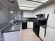 Kitchen with white cabinets, black appliances, stainless backsplash, and eat-in breakfast bar at 9209 N 59Th Ave # 206, Glendale, AZ 85302