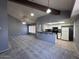 Open-concept living room and kitchen featuring vaulted ceilings, ceiling fan, and gray carpet at 9209 N 59Th Ave # 206, Glendale, AZ 85302