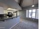 Living room featuring a vaulted ceiling, open plan, breakfast bar, and view into kitchen at 9209 N 59Th Ave # 206, Glendale, AZ 85302