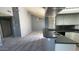An open-concept living room and kitchen features gray walls, carpeted floors, and ample natural light at 9209 N 59Th Ave # 206, Glendale, AZ 85302