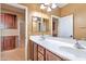 Bathroom with dual sinks, warm paint tones, and vanity storage at 9843 E Acacia Dr, Scottsdale, AZ 85260