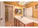 Bathroom featuring double sinks, wood cabinets, and decorative mirror at 9843 E Acacia Dr, Scottsdale, AZ 85260
