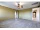 Spacious carpeted bedroom with neutral walls and trim and a ceiling fan for added comfort at 9843 E Acacia Dr, Scottsdale, AZ 85260