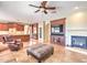Open-concept living room with fireplace, TV, and kitchen featuring dark wood cabinets and stainless steel appliances at 9843 E Acacia Dr, Scottsdale, AZ 85260
