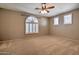Spacious main bedroom with ceiling fan and arched, shuttered windows at 9843 E Acacia Dr, Scottsdale, AZ 85260