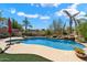 Beautiful backyard pool with rock waterfall, mature tropical landscaping, and an outdoor kitchen at 9843 E Acacia Dr, Scottsdale, AZ 85260