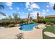 Beautiful backyard pool with rock waterfall, mature tropical landscaping, and an outdoor kitchen at 9843 E Acacia Dr, Scottsdale, AZ 85260