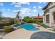 Backyard features pool with tropical landscaping, rock waterfall, a red umbrella, and outdoor seating area at 9843 E Acacia Dr, Scottsdale, AZ 85260