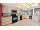 Bright kitchen with wooden cabinets, black appliances, tile floors, and backyard view at , Glendale, AZ 85302