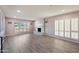 Bright living room with plantation shutters, neutral walls, a fireplace and wood flooring at , Glendale, AZ 85302