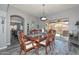 Stylish dining room showcasing a modern light fixture, luxury vinyl flooring, and convenient access to outdoor space at 15953 W Custer Ln, Surprise, AZ 85379