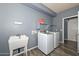 Functional laundry room featuring a utility sink, shelving, and modern washer and dryer at 15953 W Custer Ln, Surprise, AZ 85379