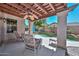 Covered patio featuring comfortable seating and a ceiling fan, overlooking the pool and backyard at 15953 W Custer Ln, Surprise, AZ 85379
