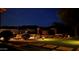 Landscaped backyard features a lawn, brick pathways, and illuminated plants and trees at night at 1607 W Pearce Rd, Phoenix, AZ 85041