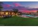 Lush backyard featuring a sparkling pool, waterfall feature, outdoor kitchen, and dining area at 1607 W Pearce Rd, Phoenix, AZ 85041