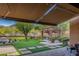 Lush backyard with a covered patio, outdoor kitchen, dining area, and inviting pool feature at 1607 W Pearce Rd, Phoenix, AZ 85041