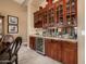 Stylish bar area featuring custom cabinetry, wine storage, and a mirrored backsplash at 1607 W Pearce Rd, Phoenix, AZ 85041