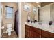 This updated bathroom includes a spacious vanity, a large mirror, and a separate shower with a privacy curtain at 1607 W Pearce Rd, Phoenix, AZ 85041