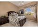 Comfortable bedroom with a decorative bed frame, bedside table, and a sunlit window with desert views at 1607 W Pearce Rd, Phoenix, AZ 85041