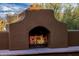 Close-up of outdoor fireplace built with desert-toned materials and stacked logs, offering warmth at 1607 W Pearce Rd, Phoenix, AZ 85041