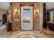 Welcoming foyer with decorative tile flooring, custom wall sconces, and an arched entry to the living spaces at 1607 W Pearce Rd, Phoenix, AZ 85041