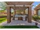 Charming outdoor kitchen featuring grill, mini fridge, granite countertops under a rustic wooden pergola at 1607 W Pearce Rd, Phoenix, AZ 85041