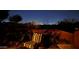 Inviting patio with a cozy chair, potted plants, and a view of the city lights at night at 1607 W Pearce Rd, Phoenix, AZ 85041