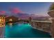Stunning pool featuring a rock waterfall, lush landscaping, and beautiful desert views in the background at 1607 W Pearce Rd, Phoenix, AZ 85041