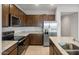 Contemporary kitchen with stainless steel appliances, granite countertops, and dark wood cabinets at 17761 W Getty Dr, Goodyear, AZ 85338