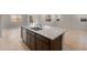Large kitchen island with granite countertops and a stainless steel sink, offering ample space for food preparation and casual dining at 17776 W Getty Dr, Goodyear, AZ 85338