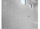 Close-up of tiled shower with sleek fixtures and bench at 17776 W Getty Dr, Goodyear, AZ 85338