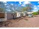 View of multiple storage sheds and car in gravel backyard at 1849 S 225Th Dr, Buckeye, AZ 85326