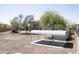 View of a spacious backyard featuring a metal canopy, a shed, mature trees and partial view of the home at 1849 S 225Th Dr, Buckeye, AZ 85326