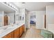 Bathroom featuring double sinks, tile floor, and a view into the bedroom at 1849 S 225Th Dr, Buckeye, AZ 85326