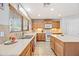 Well-lit kitchen featuring tan cabinetry, tile backsplash, and modern appliances at 1849 S 225Th Dr, Buckeye, AZ 85326