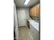 Functional laundry room with tile floors, cabinets, and a sink at 1849 S 225Th Dr, Buckeye, AZ 85326